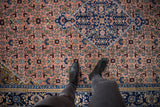 Vintage Persian Ardebil carpet's indigo blue corner spandrel and dusty blush Herati field.