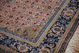 Intricate dusty blush Herati field, gold spandrel, and indigo palmette border of a Persian vintage rug.