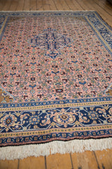 Vintage Ardebil carpet border with indigo blue, dusty blush floral motifs, and fringe.