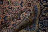 Hand-knotted Ardebil carpet's dusty blush Herati field and indigo patterned border.