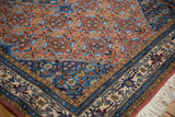 Vintage Persian Ardebil rug corner: rust Herati design, blue spandrel, beige floral border.