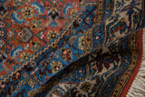 Vintage Ardebil carpet's rolled edge showcasing intact terra cotta selvage, patterned border, and fringe.