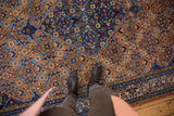 Vintage Ardebil carpet's intricate Herati motif on burnt orange field and detailed blue border.