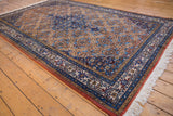 Persian Ardebil carpet corner, intricate blue border, Herati field, and ivory fringe.