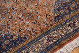 Traditional Persian Ardebil carpet's fine Herati motif, rust, blue, beige borders, and fringe.