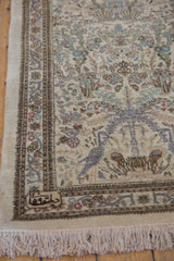 Vintage Tabriz runner corner with script, intricate border, forest scene, and fringe.