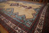 Vintage Meshkin carpet: gold field, deep ocean green geometric overlay, Herati-inspired motifs, and rust border.