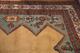 Vintage Meshkin carpet corner detail showing gold and aqua fields with rust geometric and stylized finned motifs.