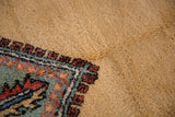 Vintage Meshkin carpet detail: pale ochre field, intricate geometric border in rust and deep ocean green.
