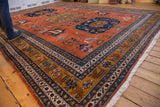 Vintage Ardebil carpet corner: pale rust field, geometric navy and pale bronze border.