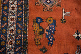 Blue and golden bird motifs within the rust field of the Vintage Ardebil carpet.