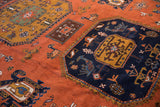 Vintage Ardebil carpet with navy geometric medallion, rust field, and stylized animal motifs.