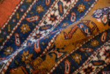 Vintage Ardebil carpet's dense pile texture with geometric navy, rust, and gold motifs.