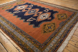 Finned contour navy medallion and gul motif on dusty sandalwood Meshkin rug.