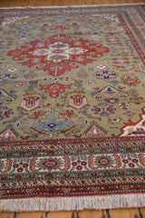 Moss green vintage Ardebil carpet showing intricate patterns, decorative border, and visible fringe.