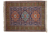Vintage Ardebil rug, triple diamond medallions and Herati floral motifs; navy, rust, green hues.