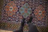 Vintage Ardebil rug with opposing diamond medallions and Herati lattice in navy, rust, sky blue.