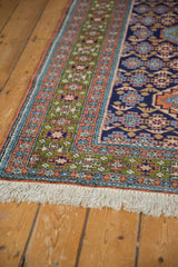 Vintage Ardebil rug corner: navy, green, terra cotta geometric borders and white fringe.