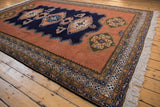 Finned bird motif with olive and pale gold details on a dusty sandalwood field.