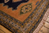 Vintage Ardebil carpet corner showcasing finned medallion detail, sandalwood field, and navy geometric borders.