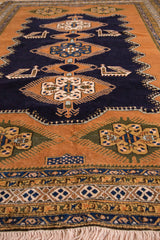 Hand-knotted Ardebil carpet border detail, showing geometric navy, gold, ivory patterns, and fringe.