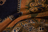 Folded vintage Ardebil carpet revealing finned patterns in deep navy, sandalwood, and olive.
