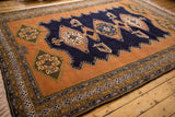 Vintage Ardebil rug corner showing geometric borders, sandalwood field, navy accents, and fringe.