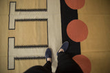 Abstract geometric contemporary Indian Kilim featuring black T-shapes and cinnabar red circles.
