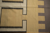 Reciprocating geometric pattern on a vintage Indian Kilim in sand, oxidized silver, and black.