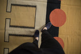Playful abstract geometric motifs in beige, black, and cinnabar red on a contemporary kilim.