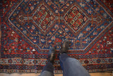 A personal view looking down at the vintage Shiraz rug's geometric medallions and sapphire blue field.