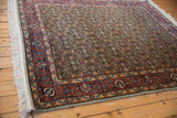 Intricate rust and blue border designs with green Herati field on a vintage Bulgarian Tabriz carpet.