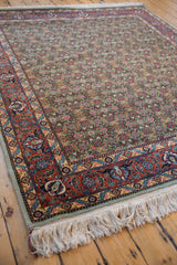 Intact ivory fringe and intricate rust, navy, gold Tabriz border of the hand-knotted rug.