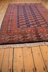 Secured ivory fringe and detailed rust and navy blue border on a fine Bokhara carpet.