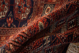 The plush, lustrous wool pile and fine weave of a vintage Bokhara carpet revealed in a fold.