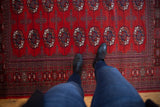 Fine weave cherry red Bokhara rug, geometric navy blue and ivory gul medallions.