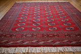 Hand knotted Bokhara rug with a cherry red geometric border and ivory fringe.