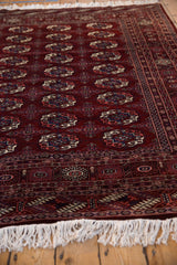 Low angle view highlighting the plush wool pile and repeating gul medallions of a vintage Bokhara rug.