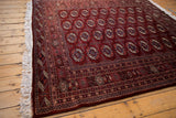 Lustrous maroon red pile of a vintage Bokhara carpet showing its dynamic sheen and detailed gul medallions.