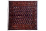 Vintage Pakistani Bokhara square carpet with an allover pattern of rust-red gul medallions on a navy field.
