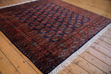 Angled view of a fine Pakistani Bokhara rug's lustrous wool pile and repeating gul medallions.