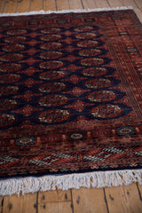 Plush, lustrous wool pile and fine weave of a vintage Bokhara design rug from a low angle.