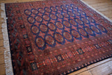 Vintage Pakistani Bokhara rug showing the dynamic sheen across its geometric red and blue design.