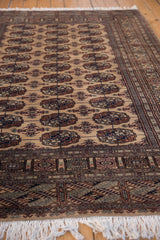 Geometric border in copper, navy, and beige with secure off-white fringe.