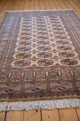 Fully secured ends with white fringe and geometric border pattern in camel, beige, copper.