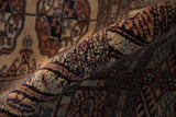 Plush, silk-like pile on rolled vintage Bokhara carpet featuring camel, beige, navy geometric florals.