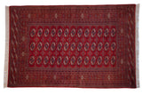 Vintage Pakistani Bokhara rug with repeating red, navy, and ivory gul medallions and intricate borders.