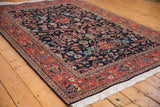 Deep brick red meandering vine border and navy gul ferang motif on Indian Bijar rug.