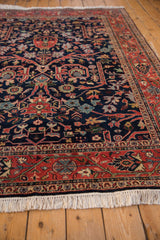 Vintage Indian Bijar rug detail: brick red vine border, navy field, and cream fringe.