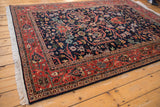 Detailed view of the vintage Indian Bijar rug's brick red meandering vine border.